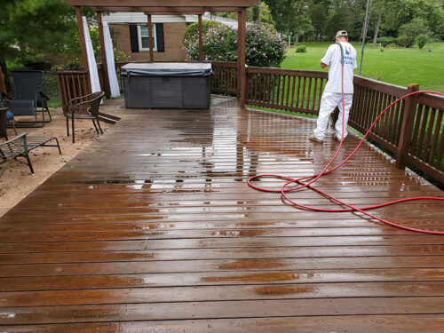 contractor pressure washing wooden deck at residential property backyard bellbrook oh