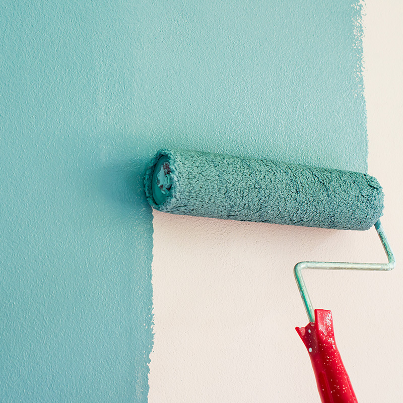 paint roller close up painting a white wall with light blue color bellbrook oh